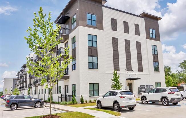 Modern four-story apartment building with balconies facing the front street parking