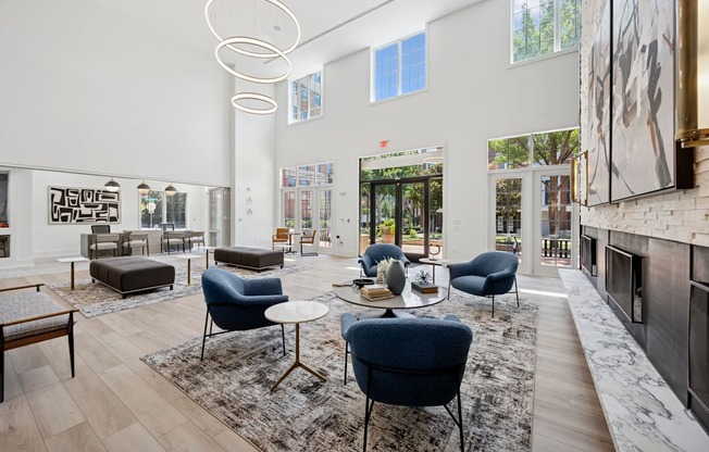 A modern living room with blue chairs and a fireplace.
