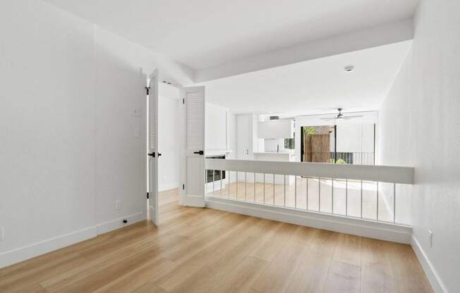 a living room with a balcony and a door to a kitchen