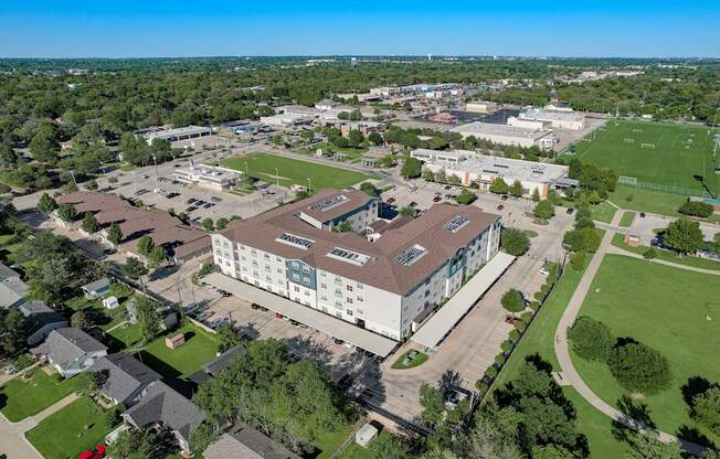 an aerial view of a campus with a building and a field