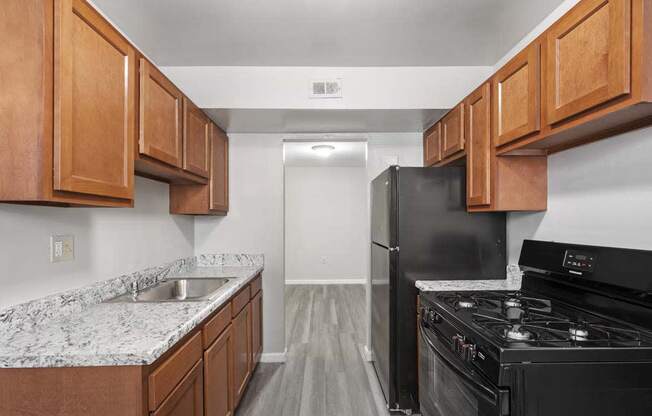 a kitchen with wood cabinets and a black stove and refrigerator