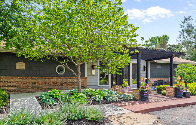 the front of a house with a porch and a tree