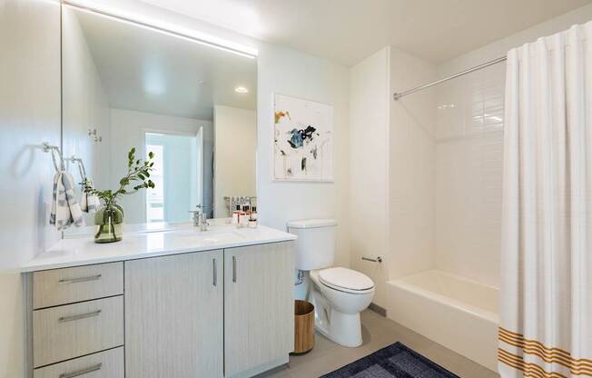 A white bathroom with a toilet, sink, and bathtub.