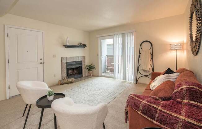 Model living room with a fireplace and a couch at Pheasant Pointe Apartments, California, 95833