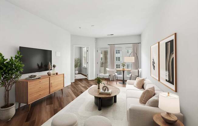 A modern living room with a flat screen TV, a coffee table, and a large window.