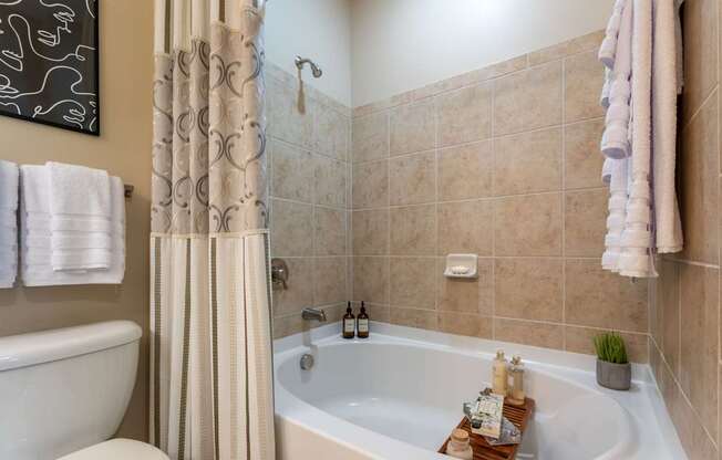 A bathroom with a white tub and a shower curtain.