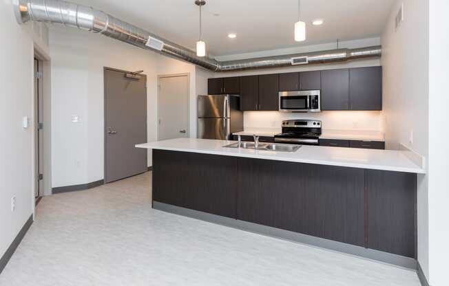 Modern open-concept kitchen and living area with stainless steel appliances.