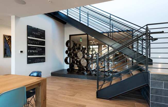 A modern staircase with a metal railing and wooden steps.