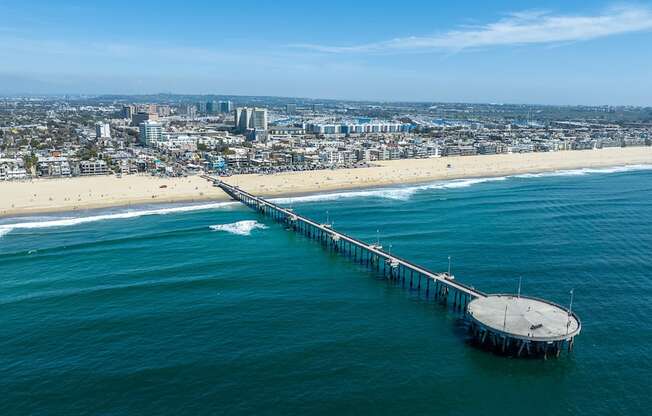 a view of the pier from the air with the beach and city in the background