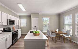 A kitchen with a table and chairs.
