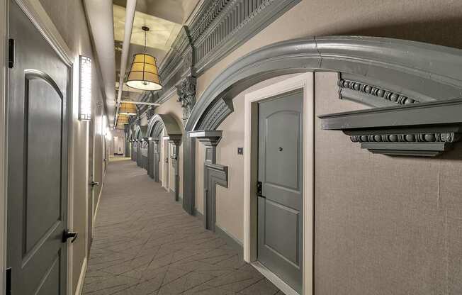 a hallway with white doors and a ceiling with a light fixture at The Knights @ 506 Delaware Apartments, Buffalo