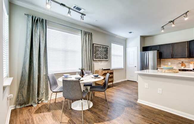 a dining room and kitchen with a table and chairs