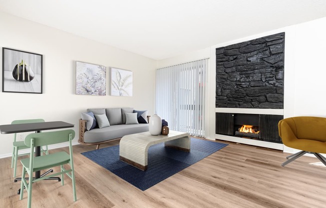 A living room with a fireplace and a grey couch.