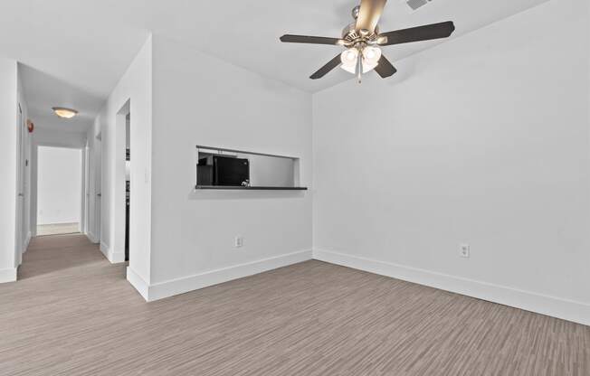 a living room with a ceiling fan and a television