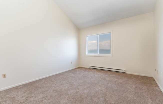 a bedroom with white walls and carpet