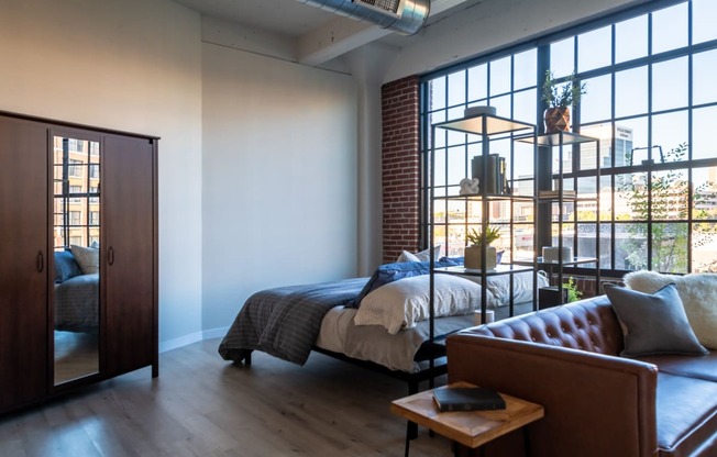 a bedroom with a bed and a large window at The 22 Apartments, St. Louis