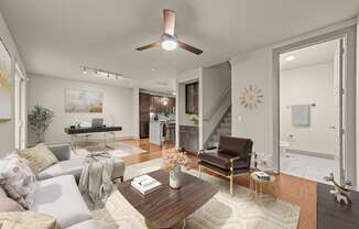 A living room with a couch, a coffee table, and a ceiling fan.