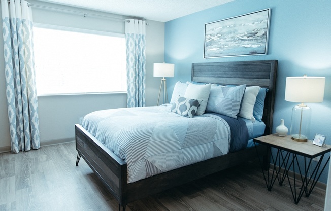 a blue and white bedroom with a bed and a window