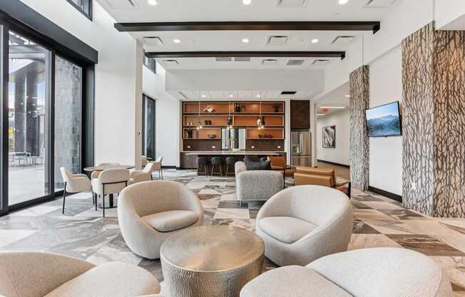A modern living room with a large sofa and a TV on the wall.
