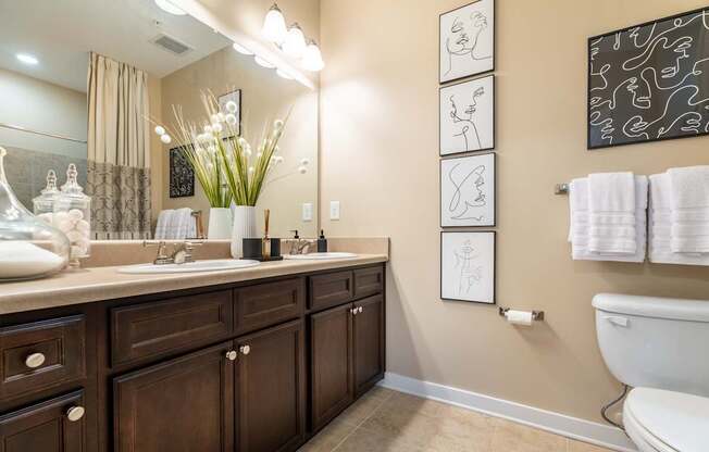 A bathroom with brown cabinets and a white toilet.