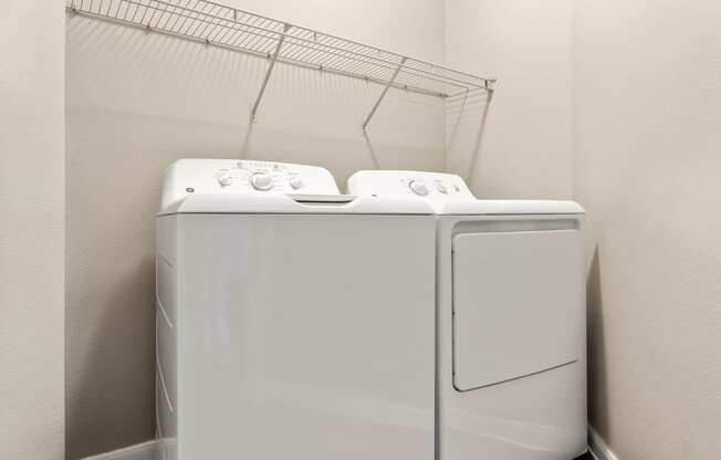 a washer and dryer in a room with a rack on the wall at Villages of Cypress Creek, Texas, 77070