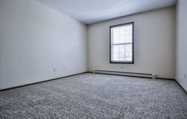 Grand Forks Primrose Apartments an empty room with a window and carpet