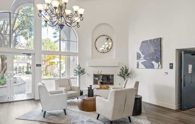 a living room with white furniture and large windows