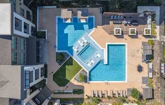 A swimming pool with a slide and a hot tub.