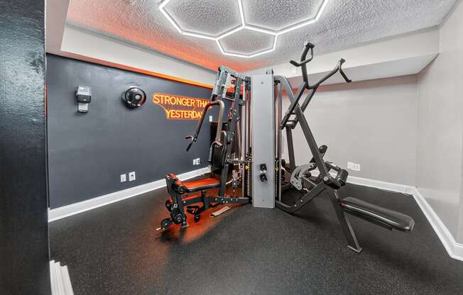 A gym room with a rowing machine and a weight machine.