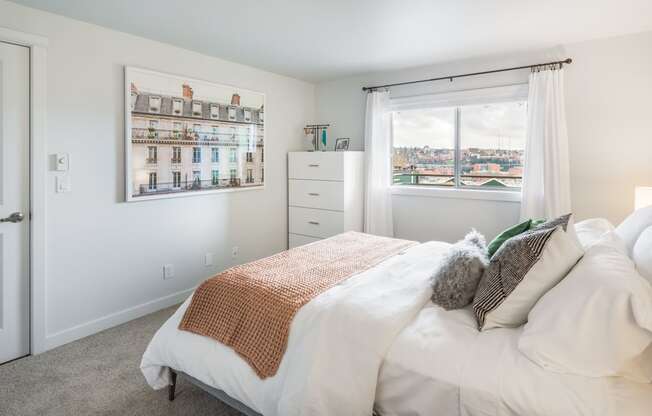 a bedroom with a bed and a window and a dresser