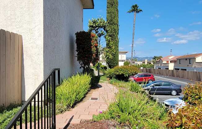 Paver walkway and gardens around apartment building at Plaza Verde Apartments in Escondido, California.