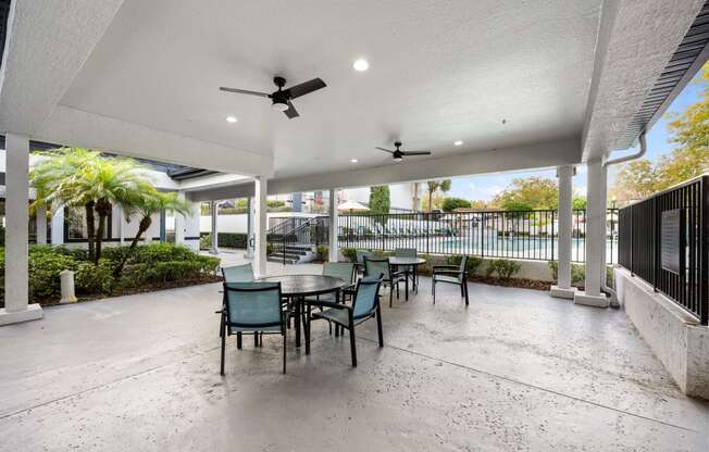 a patio with a table and chairs and a ceiling fan