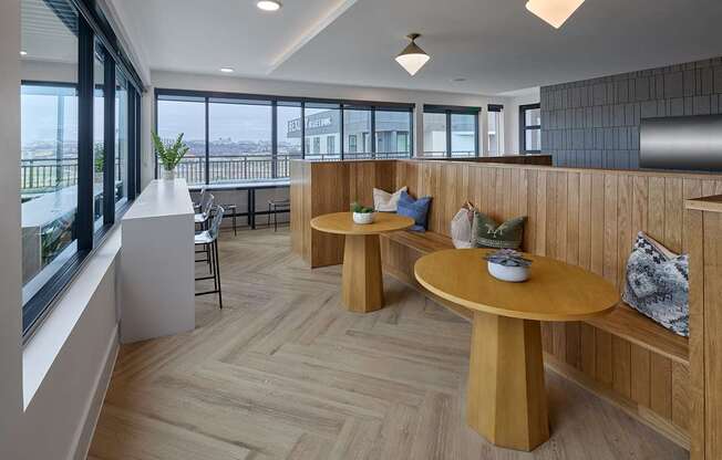 A modern dining area with wooden furniture and a view of the city.