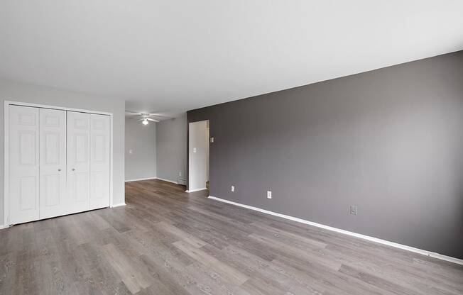 an empty living room with wood floors and a white door