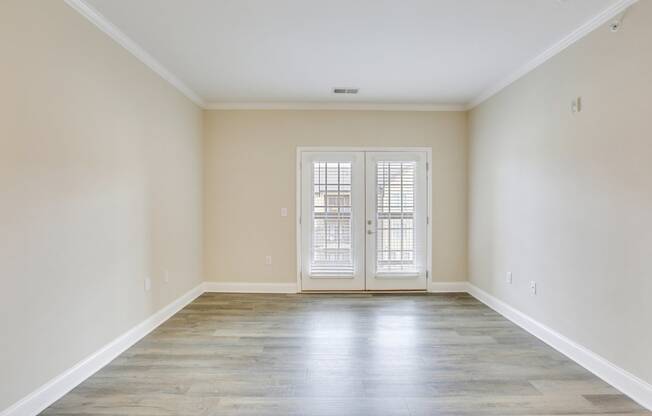 an empty living room with white walls and doors