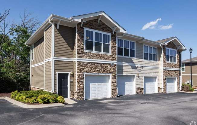 the front of a tan and with two garage doors