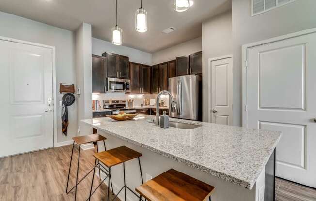A kitchen with a white countertop and wooden stools.