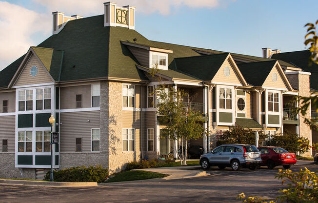 a large apartment building with cars parked in front of it