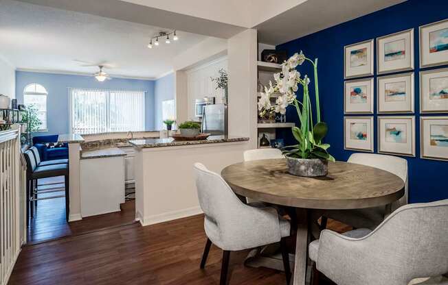 Dining nook with blue accent wall beside open kitchen