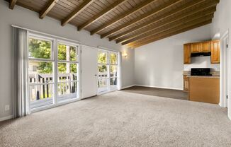 A spacious room with a wooden ceiling and carpeted floor.