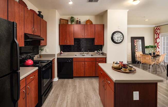 A kitchen with wooden cabinets and black appliances.