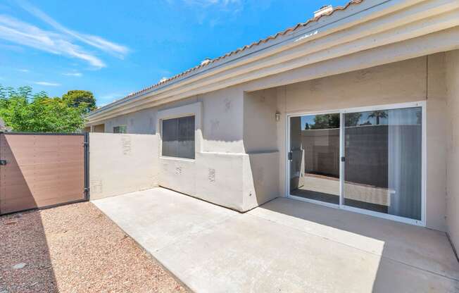 a patio in front of a house with a sliding glass door