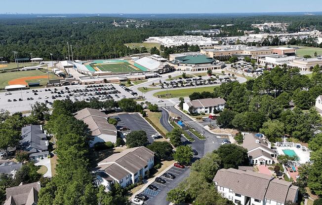 A bird's eye view of a residential area with houses, a school, and a football field.
