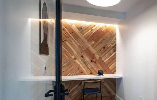 A wooden wall with a table and chair in front of it.