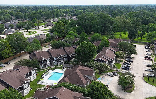 A bird's eye view of a residential area with houses and a swimming pool.