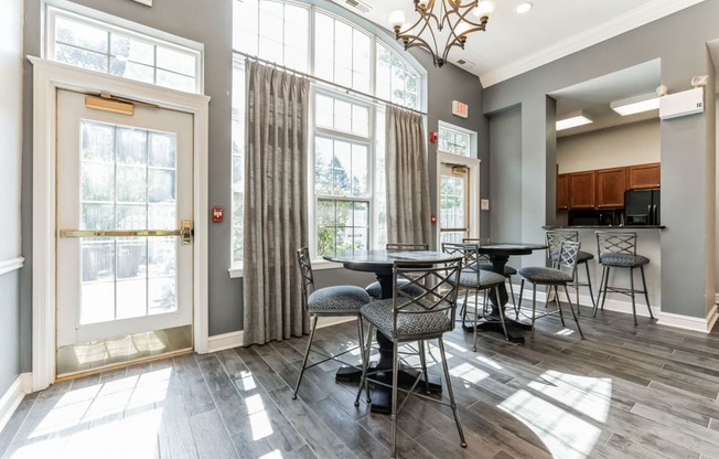 a dining room with tables and chairs and large windows