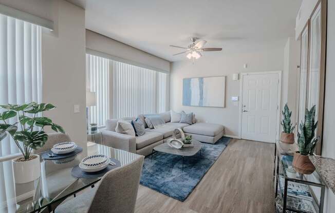 A living room with a couch, a coffee table, and a ceiling fan.