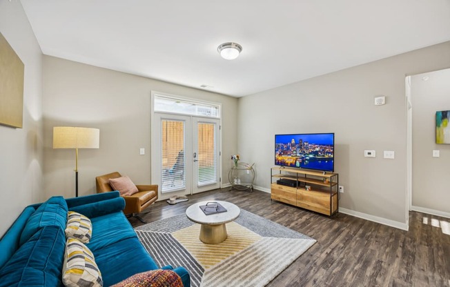 A living room with a blue couch and a television.