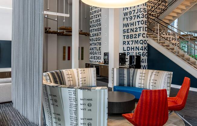 the lobby of a library with a red chair and a table