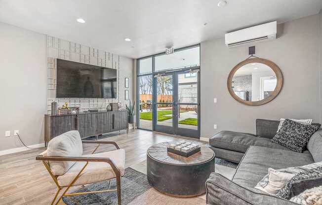 a living room with grey couches and a round coffee table